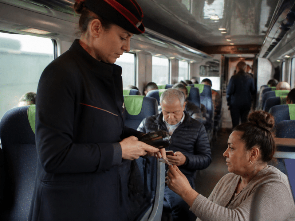 Agent SNCF verifiant tickets dans train en mouvement.