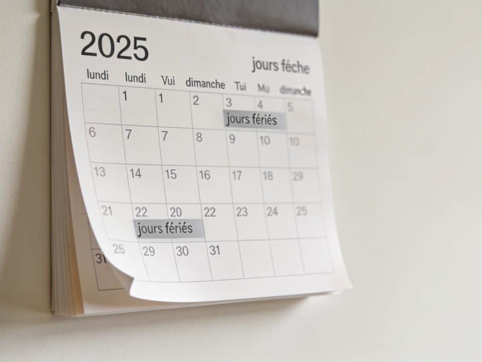 Calendrier mural affichant dates et jours de travail 2025.