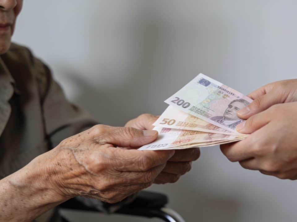 Personne agee recevant des billets de banque des mains