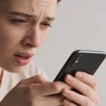Personne regardant telephone avec expression confuse et inquiete