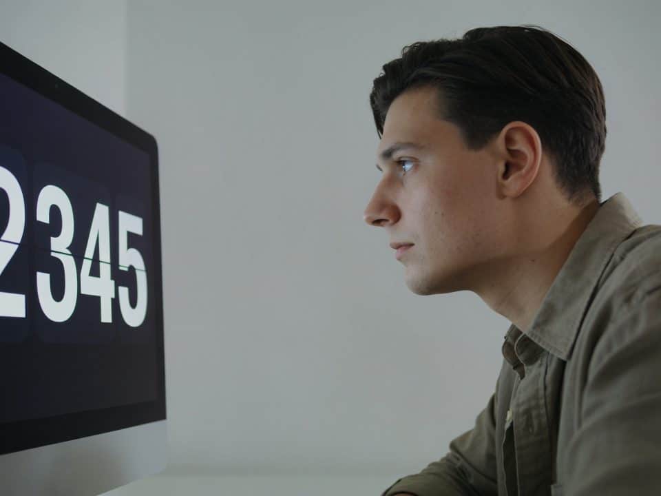 Personne regardant fixement un ecran affichant des chiffres numeriques.
