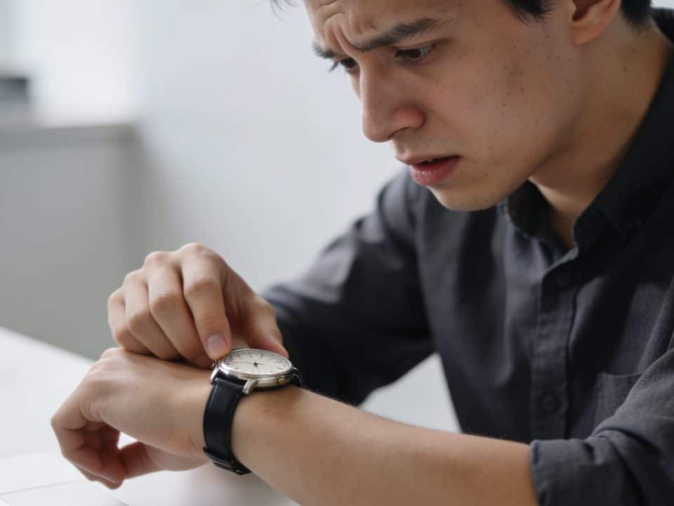 Personne regardant montre, expression inquiete, bureau arriere-plan
