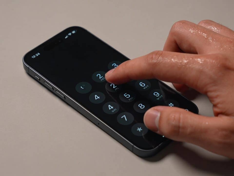 Personne tapant numero telephone sur clavier portable